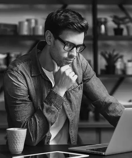 Junger Mann mit Haaren ließ sich die Webseite von Hairmedic auf dem Laptop durch